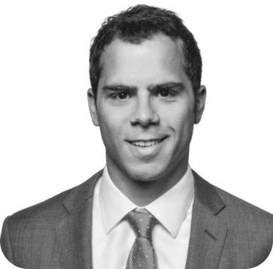 Black and white headshot of a smiling man in a suit and tie.