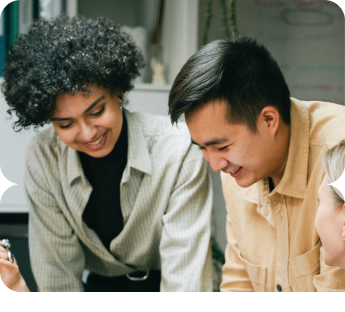 Three young professionals collaborating over documents at a table.