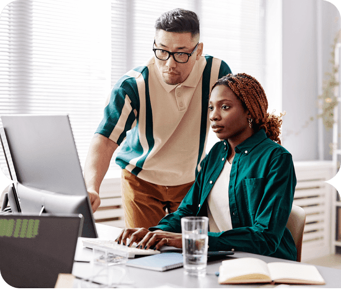 Two colleagues looking intently at a computer screen.